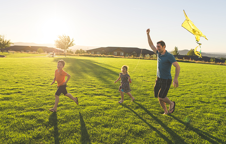 family flying kite on grass