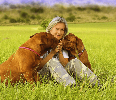 Women with dogs in a field
