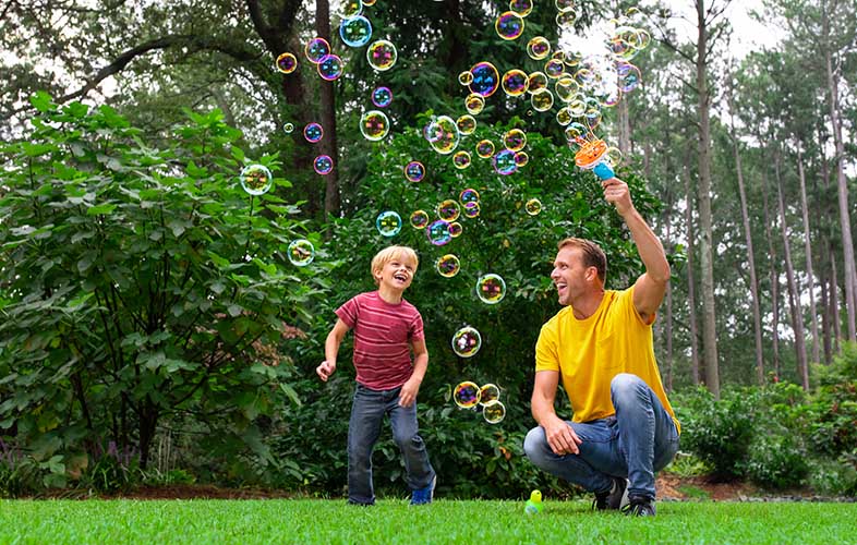 family playing with bubbles outside