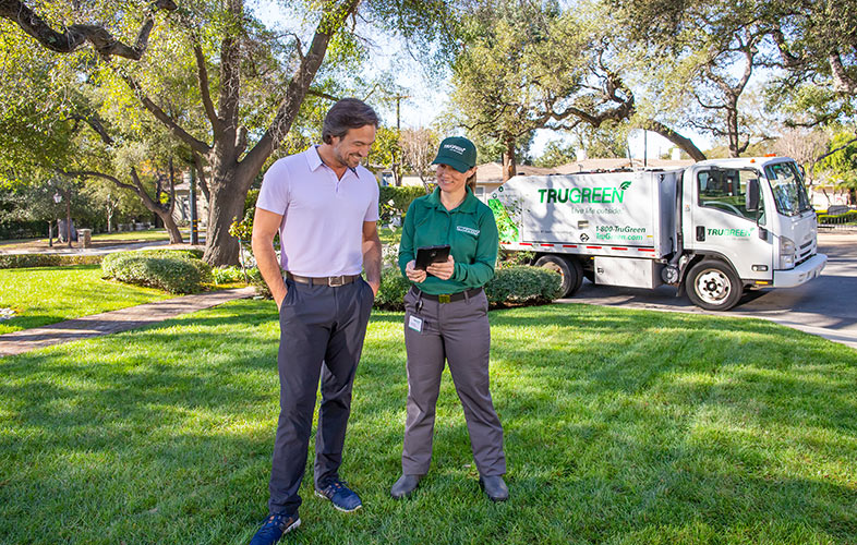 TruGreen specialist with homeowner on lawn