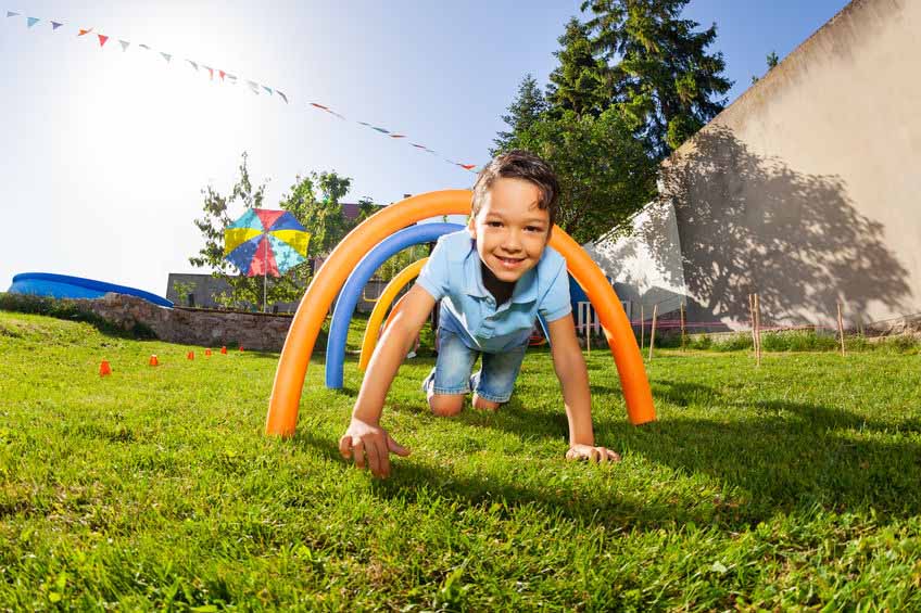 Child doing an obstacle course on lawn