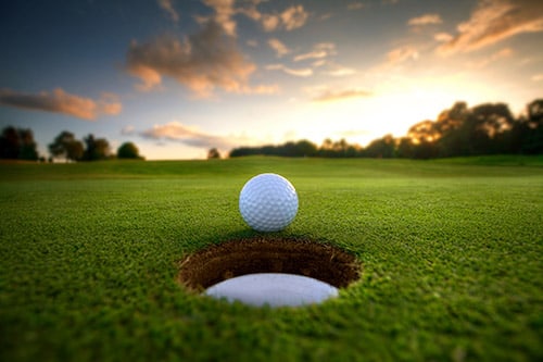 <p>Major championship golf course with a ball on the green next to the hole</p>