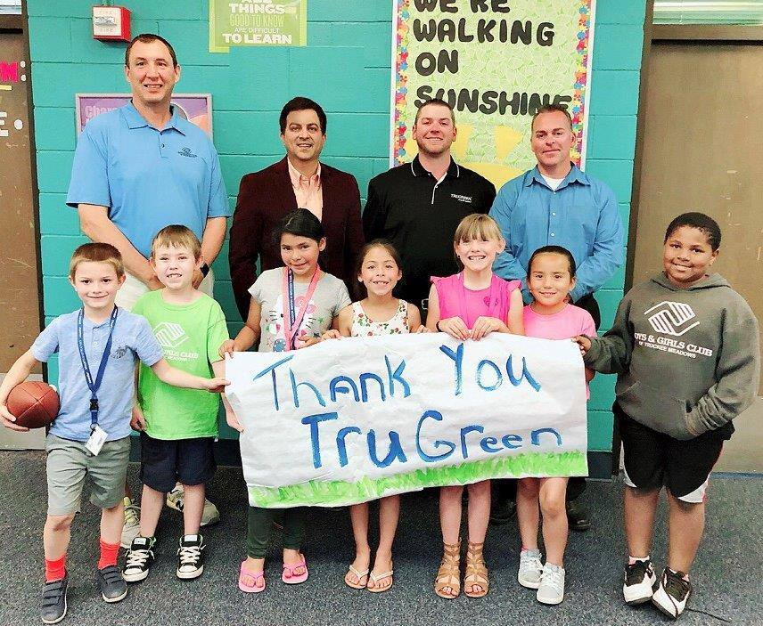 A group of adults and children holding a thank you sign