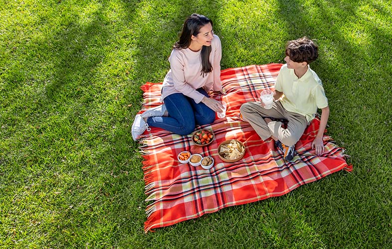 mother and son enjoying picnic on lawn