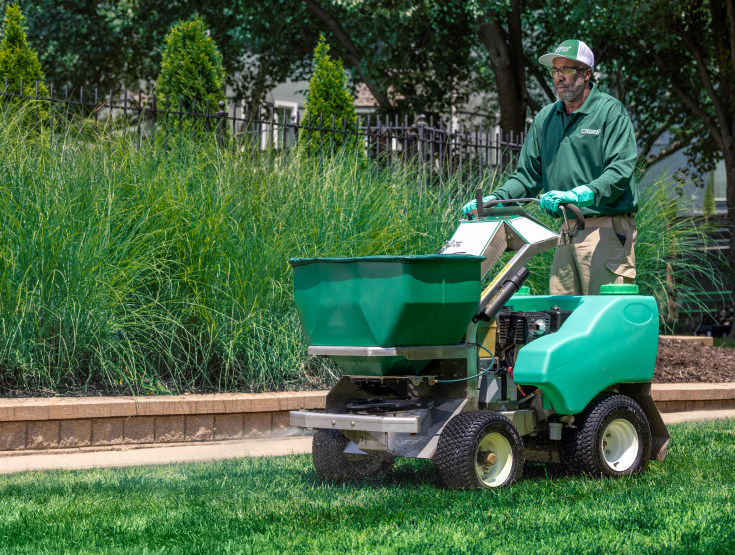 TruGreen specialist fertilizing a lawn