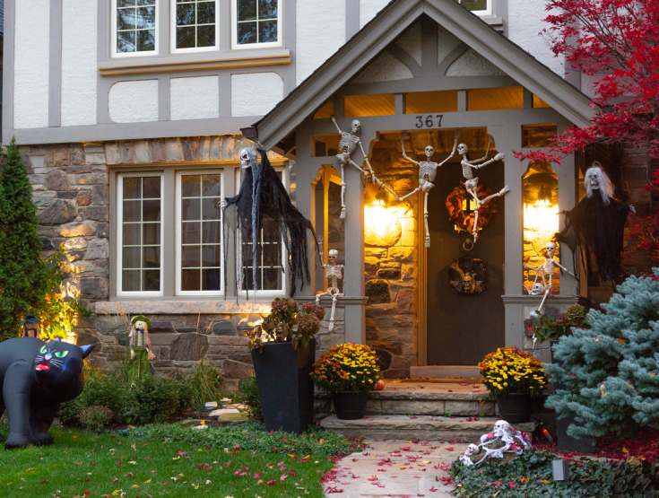 House decorated for Halloween with a lush, green lawn in front of it