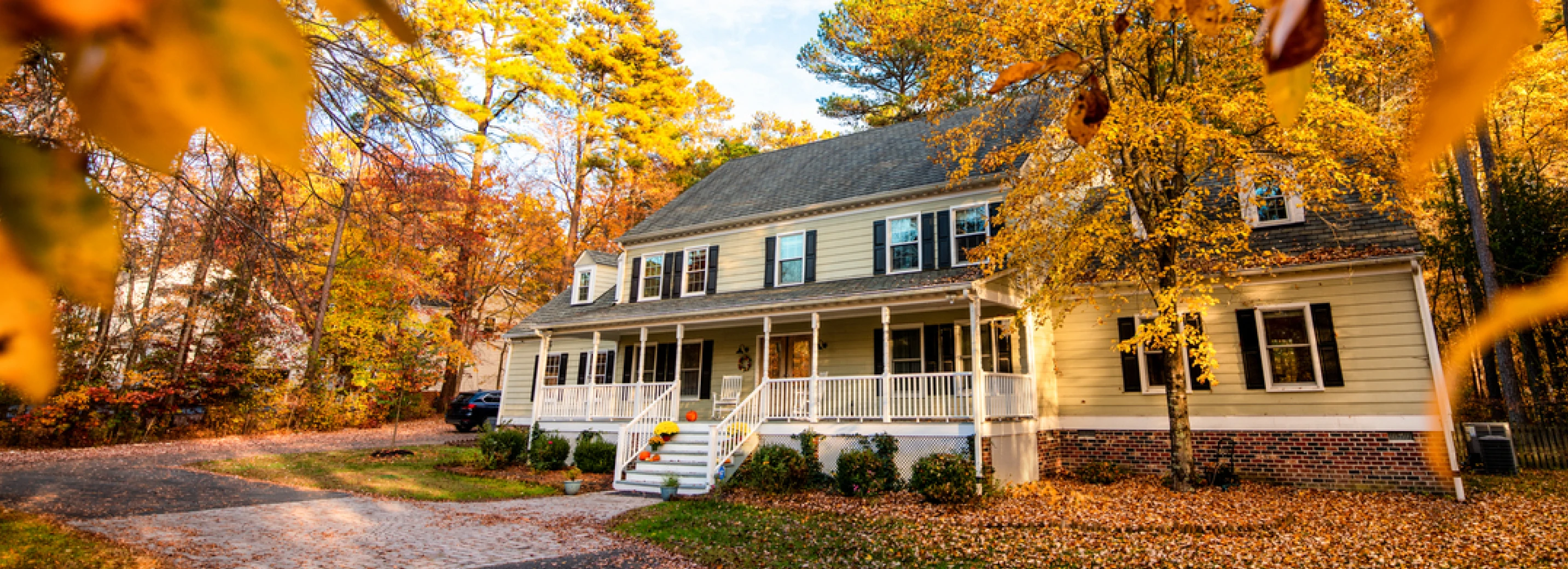 Beautiful home in the fall with leaves on the lawn