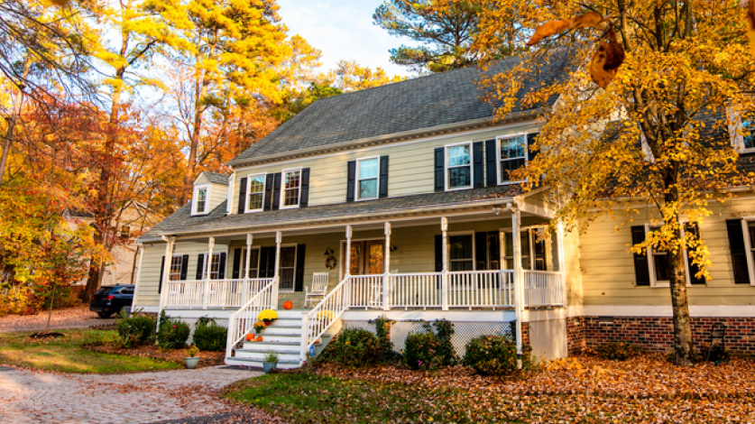 Beautiful home in the fall with leaves on the lawn