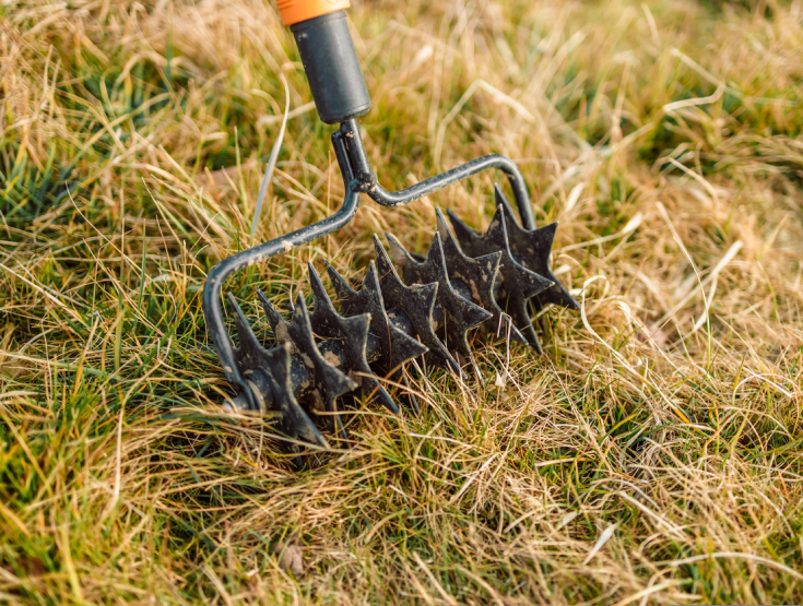 DIY spike aerator pushing holes into a lawn