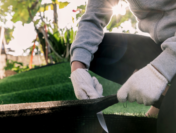 Closeup of someone cutting and installing artificial turf