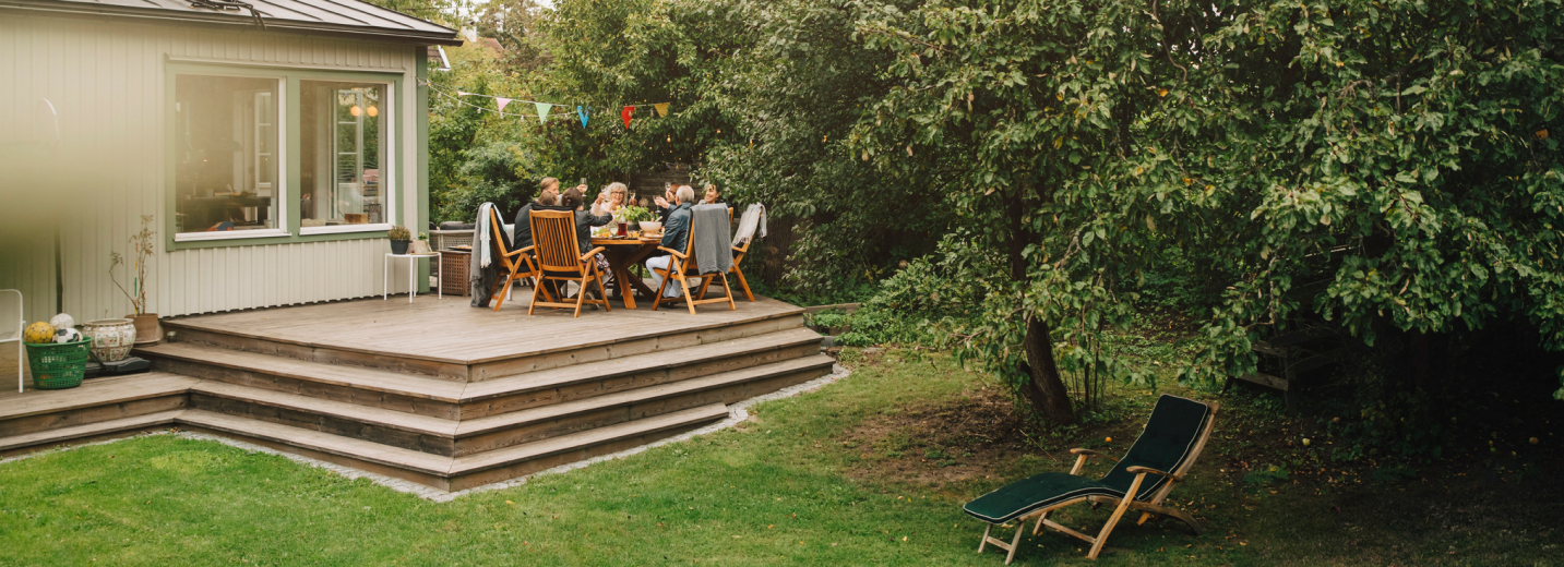 A family enjoying a meal on their back porch in the summer outside
