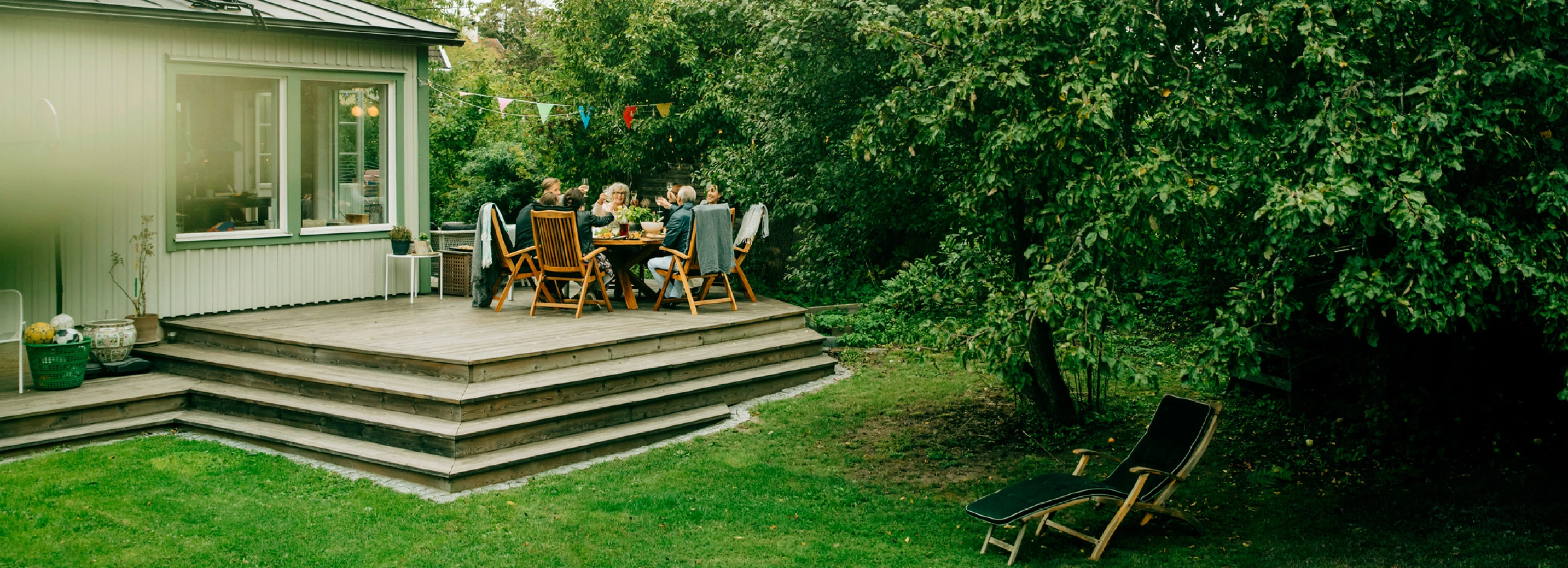 A family enjoying a meal on their back porch in the summer outside