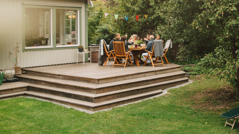 A family enjoying a meal on their back porch in the summer outside