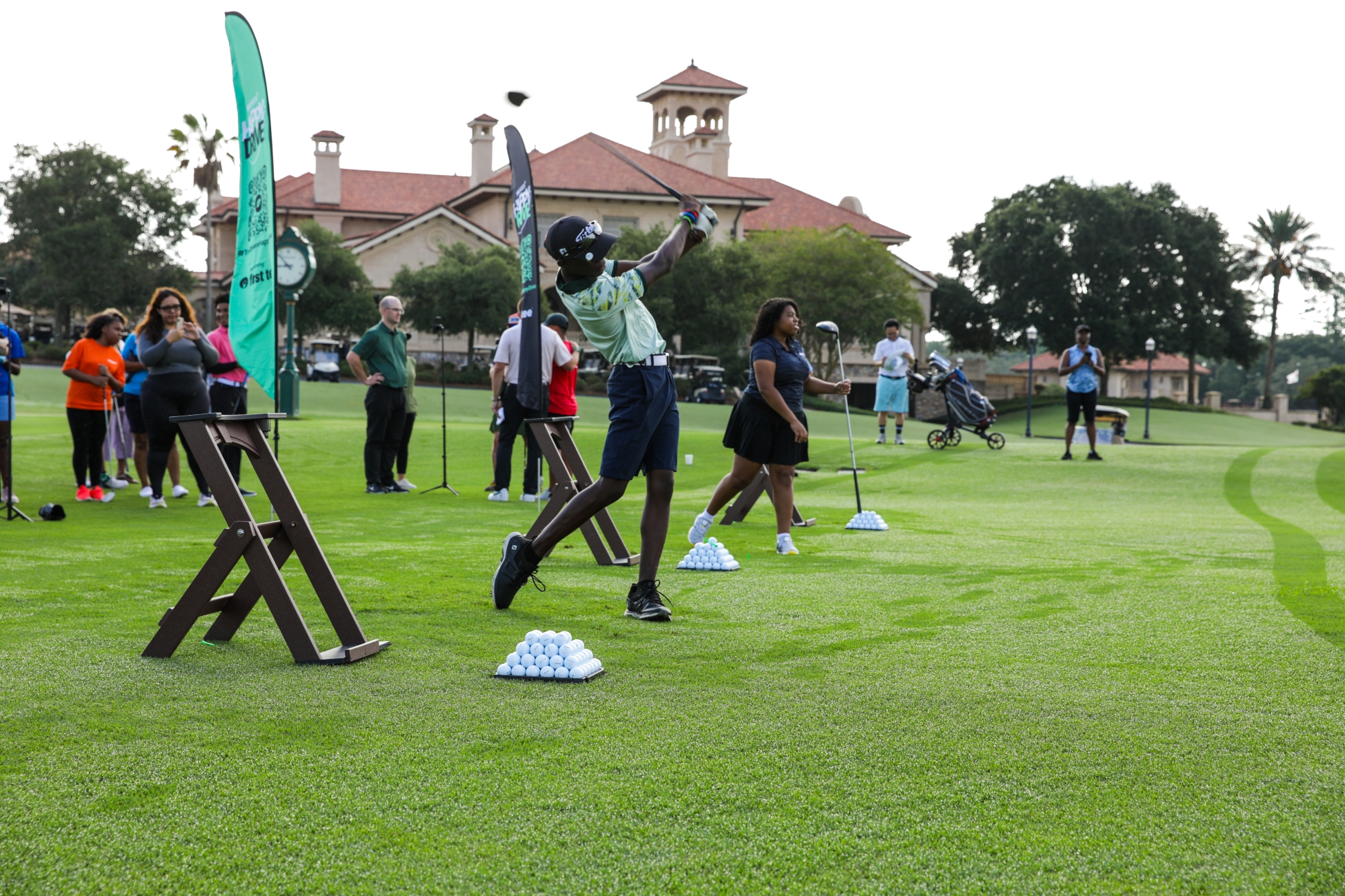 First Tee golfers swinging golf clubs at Happy Drive kickoff event
