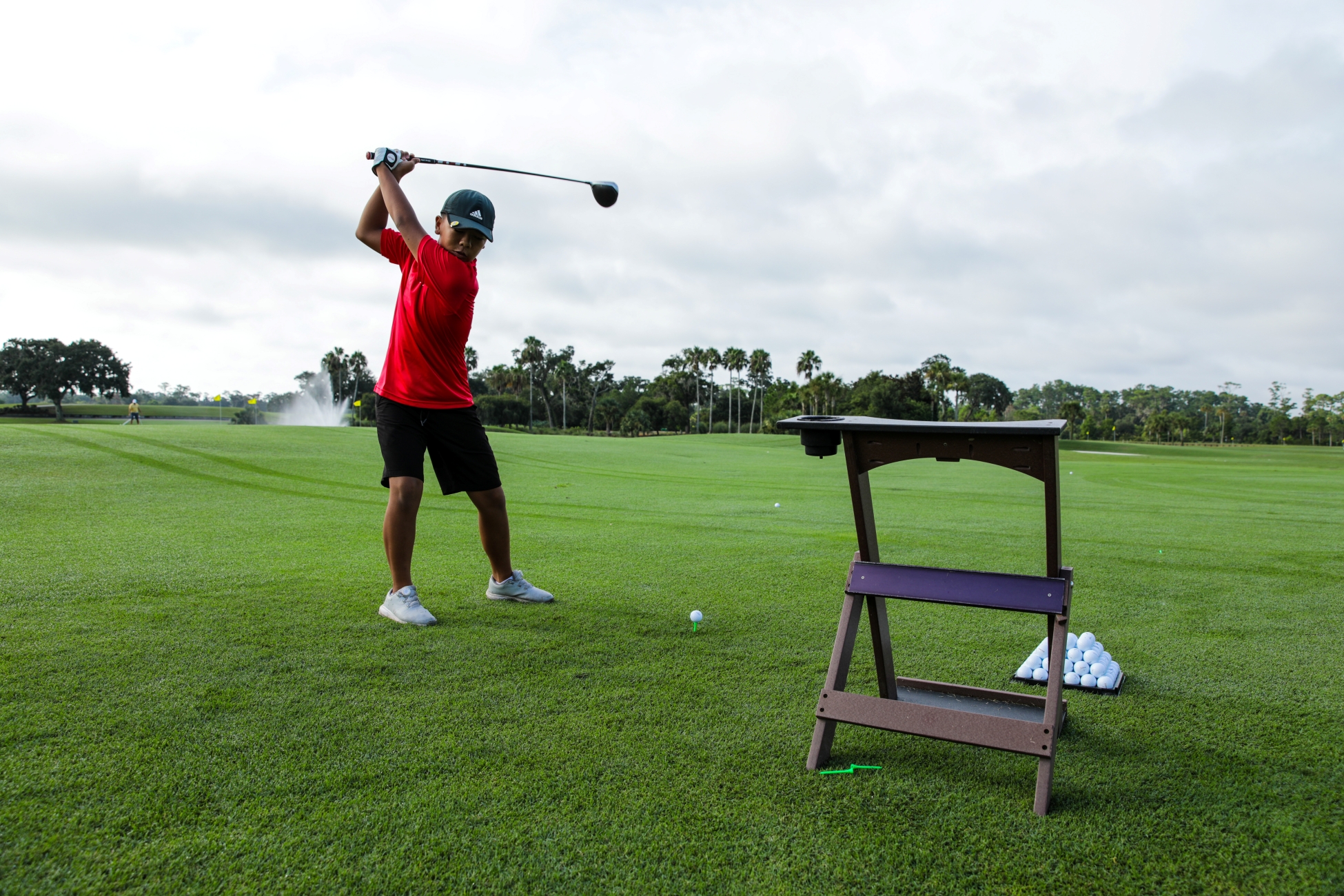 First Tee member swinging a golf club at the Happy Drive kickoff event