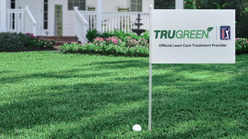 Lush, green lawn with a flag in it that has the TruGreen logo and the PGA TOUR logo