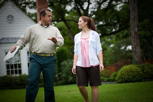 TruGreen specialist walking on a lawn with customer