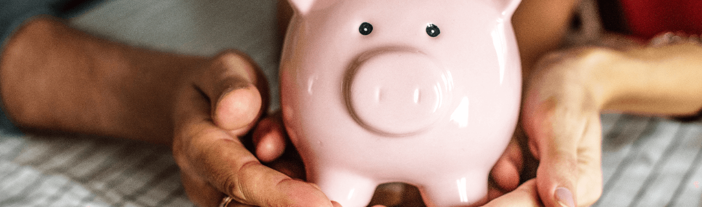 Close up of hands holding a piggy bank