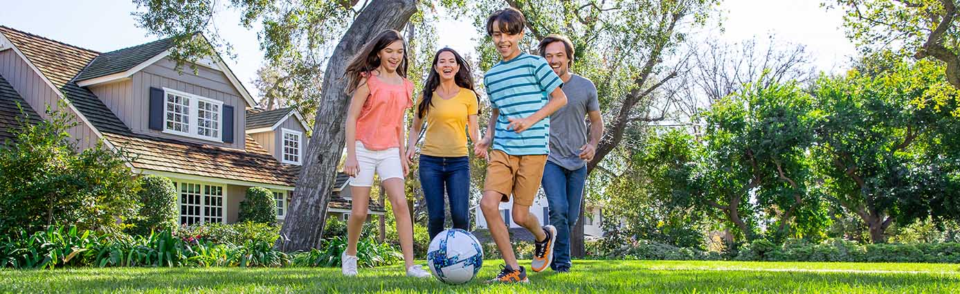 Family playing soccer on lawn