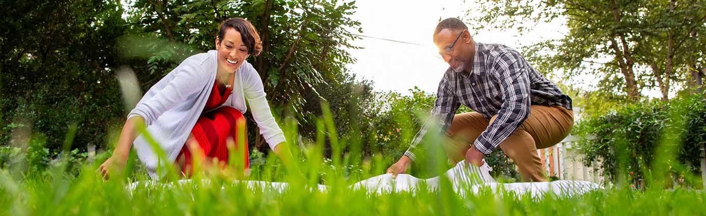 A couple eating a picnic on healthy lawn