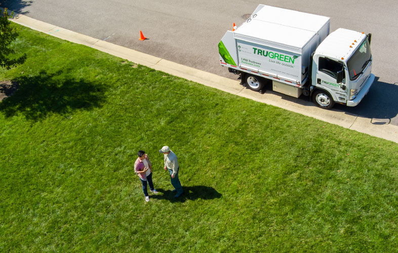 TruGreen specialist with customer on lawn